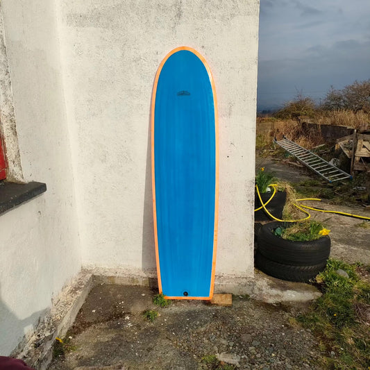 Deck of a Booglerize surfboards blue and orange finless board shaped by Elvis Beetham
